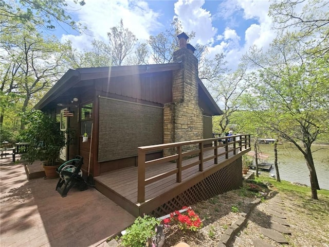 view of side of property with a wooden deck, a chimney, and brick siding