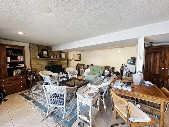 living room with visible vents, a textured ceiling, light tile patterned flooring, and a large fireplace
