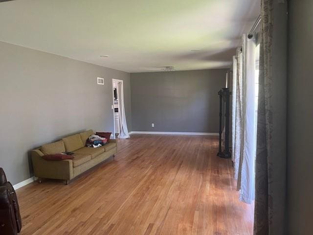 unfurnished living room featuring baseboards and wood finished floors