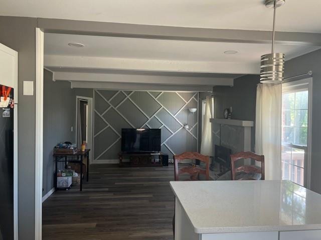 dining space featuring baseboards, beamed ceiling, and dark wood finished floors