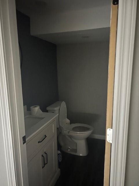 bathroom featuring vanity, baseboards, and toilet