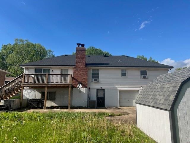 back of house with a deck, stairway, an outdoor structure, a storage unit, and an attached garage