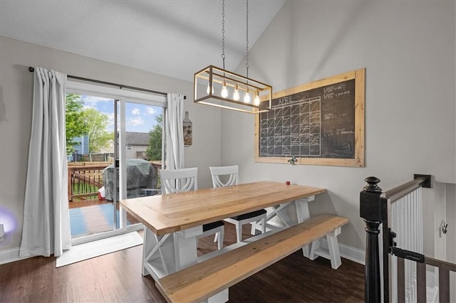 dining area with baseboards, vaulted ceiling, and wood finished floors