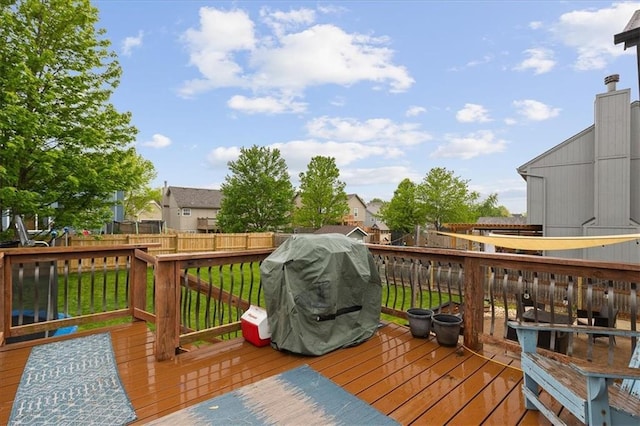 wooden deck featuring a fenced backyard, grilling area, and a residential view