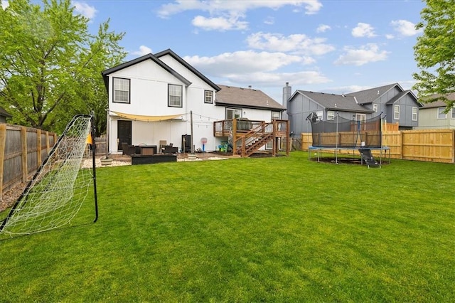 back of property featuring stairs, a fenced backyard, a trampoline, and a wooden deck