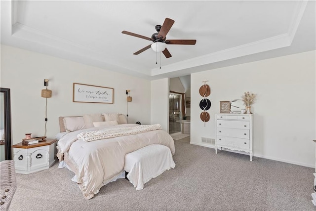 carpeted bedroom featuring visible vents, connected bathroom, a raised ceiling, and crown molding