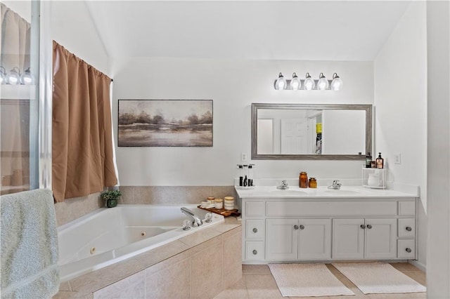 full bathroom featuring double vanity, tile patterned floors, a tub with jets, and a sink