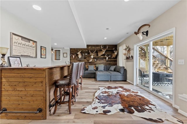 living area featuring baseboards, recessed lighting, light wood finished floors, and bar area