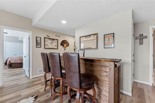 bar featuring baseboards, recessed lighting, wood finished floors, and visible vents
