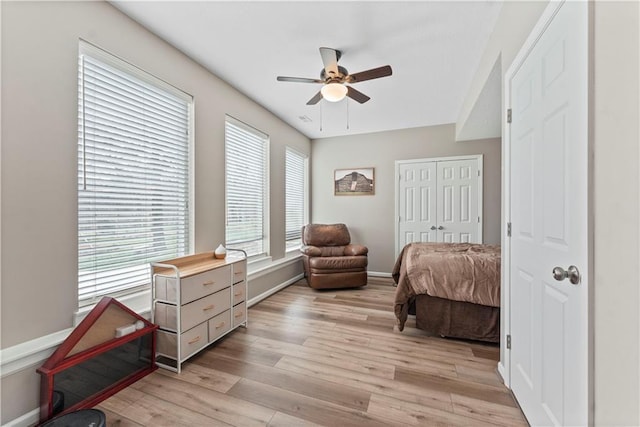 bedroom featuring a ceiling fan, baseboards, a closet, and light wood-type flooring