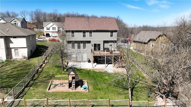 back of house with a lawn, a fenced backyard, and a playground