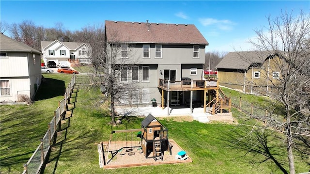 rear view of house with fence, a deck, stairs, a playground, and a lawn