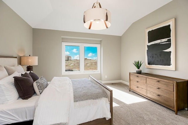 carpeted bedroom with vaulted ceiling and baseboards