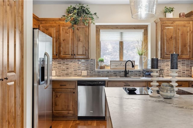 9924 Skyview Ln, Lenexa, KS 66220 - kitchen with appliances with stainless steel finishes, a sink, light countertops, tasteful backsplash, and brown cabinetry