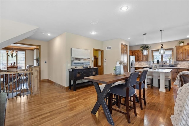 9924 Skyview Ln, Lenexa, KS 66220 - dining area featuring light wood-style flooring, recessed lighting, baseboards, and a chandelier