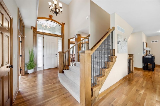 9924 Skyview Ln, Lenexa, KS 66220 - foyer entrance with light wood-type flooring, stairway, a chandelier, baseboards, and a towering ceiling