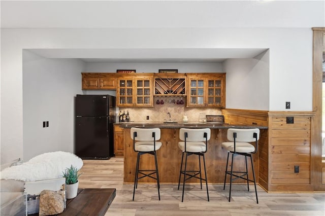 9924 Skyview Ln, Lenexa, KS 66220 - indoor wet bar featuring freestanding refrigerator, light wood-style flooring, and backsplash