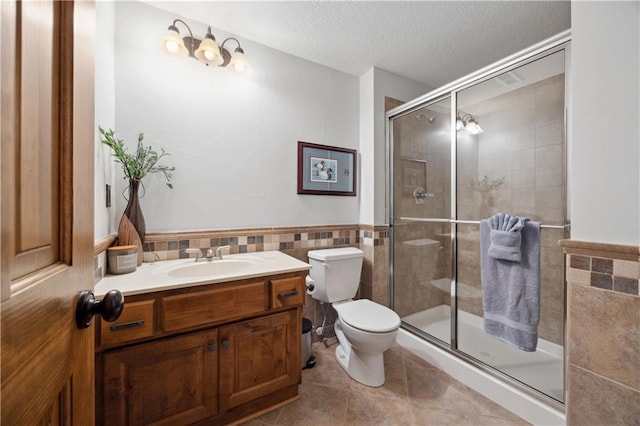 9924 Skyview Ln, Lenexa, KS 66220 - bathroom featuring tile walls, toilet, a stall shower, a textured ceiling, and tile patterned floors
