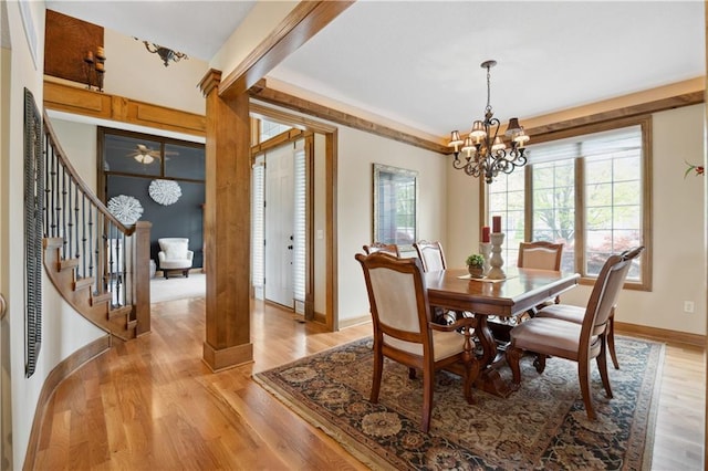 9924 Skyview Ln, Lenexa, KS 66220 - dining area featuring a chandelier, baseboards, stairway, and light wood-style flooring