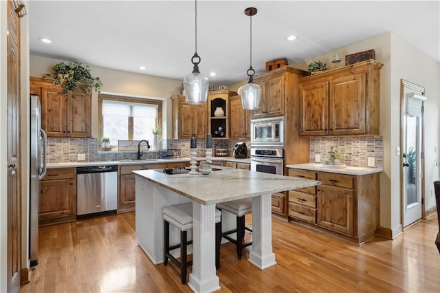 9924 Skyview Ln, Lenexa, KS 66220 - kitchen with stainless steel appliances, brown cabinetry, a kitchen breakfast bar, open shelves, and recessed lighting