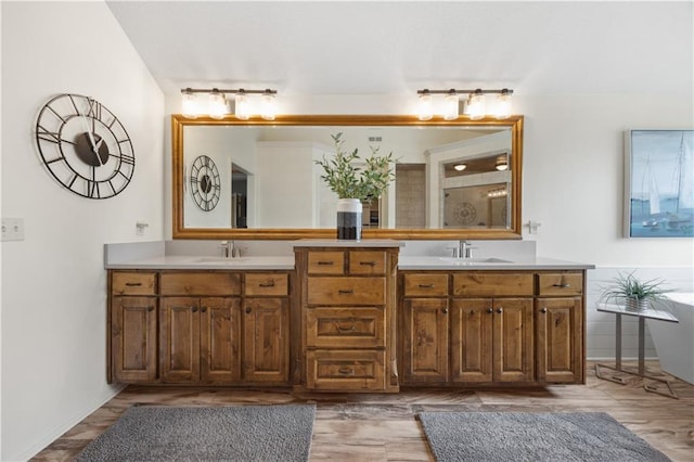 9924 Skyview Ln, Lenexa, KS 66220 - bathroom with double vanity, a soaking tub, and wood finished floors