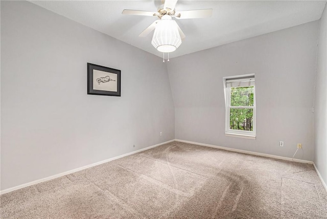 carpeted spare room featuring baseboards and ceiling fan