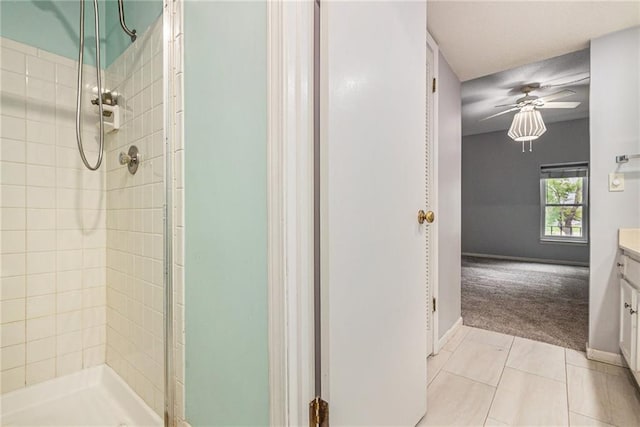full bathroom with vanity, baseboards, a ceiling fan, and a shower stall