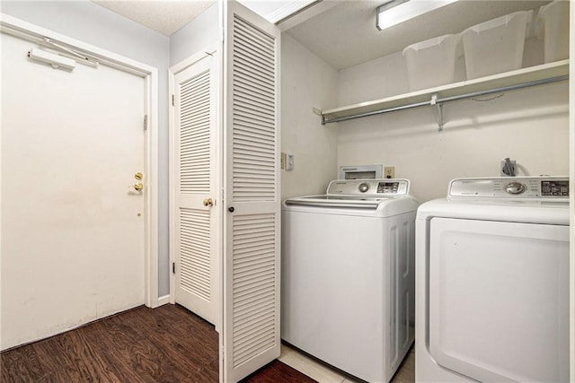 laundry room with laundry area, wood finished floors, and washing machine and clothes dryer