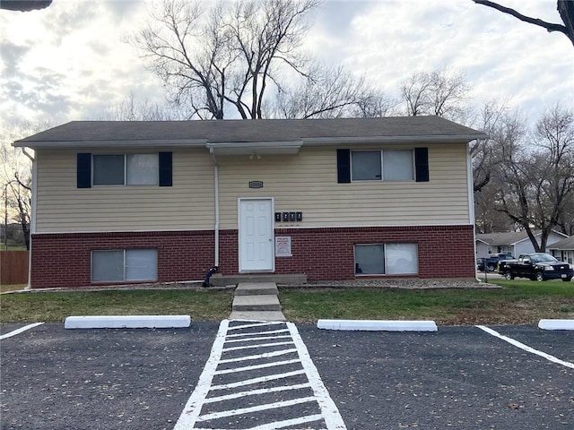 split foyer home with brick siding and uncovered parking