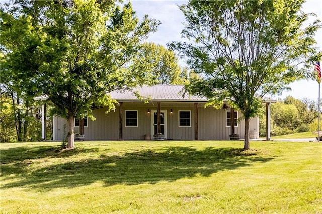 back of house featuring a porch, a yard, and metal roof