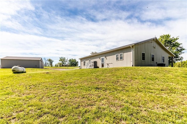 rear view of property featuring a yard and board and batten siding