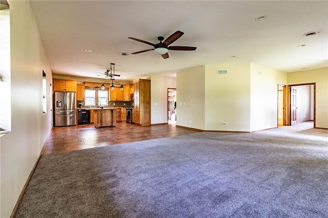unfurnished living room featuring baseboards, a ceiling fan, dark carpet, recessed lighting, and a sink