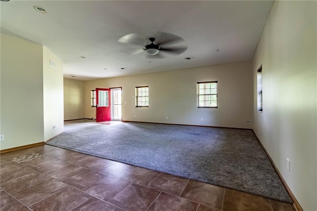 spare room with carpet, a ceiling fan, and baseboards