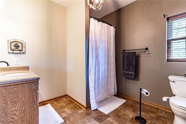 full bath featuring toilet, vanity, baseboards, and curtained shower