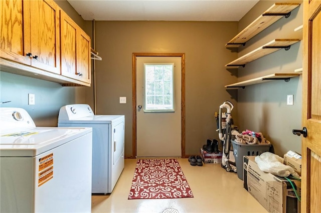 washroom featuring washing machine and dryer and cabinet space