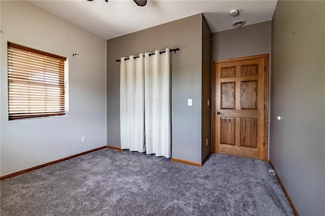 unfurnished bedroom with carpet flooring, baseboards, and ceiling fan