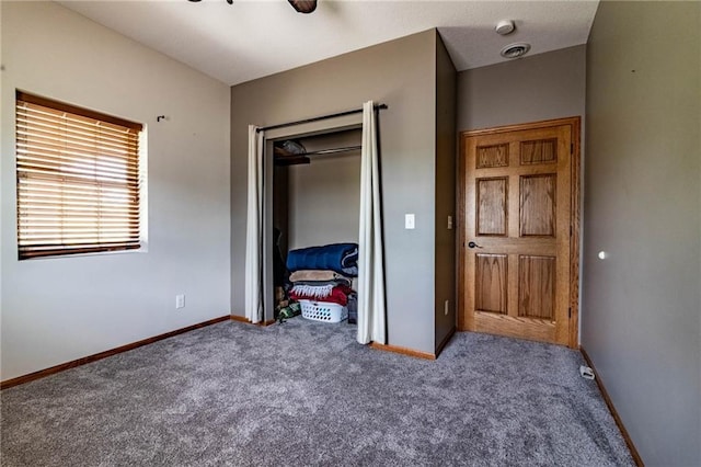 carpeted bedroom with baseboards, a closet, and a ceiling fan