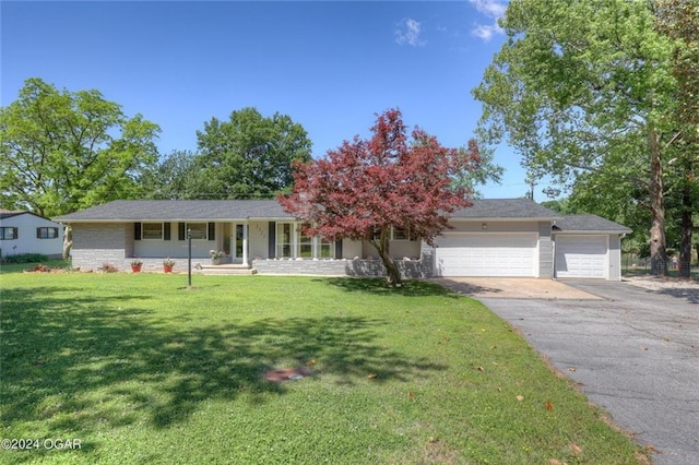view of front of property featuring a porch, aphalt driveway, a front yard, and a garage
