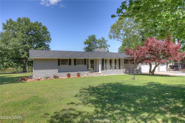 ranch-style house with covered porch, a chimney, a front yard, an attached garage, and stone siding
