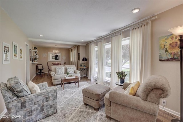 living area with baseboards, recessed lighting, wood finished floors, and a chandelier