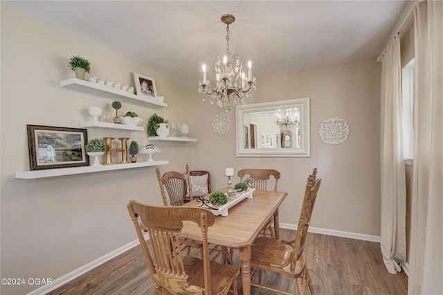 dining space with baseboards, an inviting chandelier, and wood finished floors