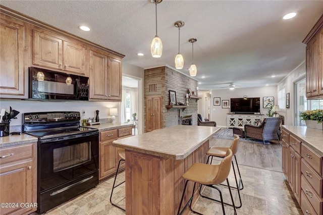 kitchen with a kitchen bar, a fireplace, light countertops, black appliances, and open floor plan