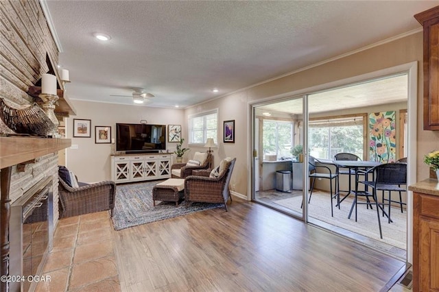 living room with ornamental molding, a textured ceiling, and ceiling fan