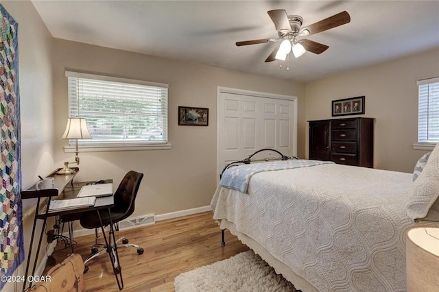 bedroom with baseboards, ceiling fan, wood finished floors, and a closet
