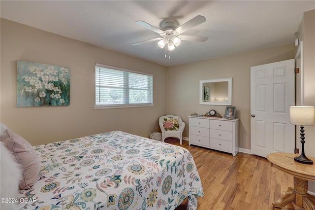 bedroom featuring baseboards, ceiling fan, and light wood-style flooring