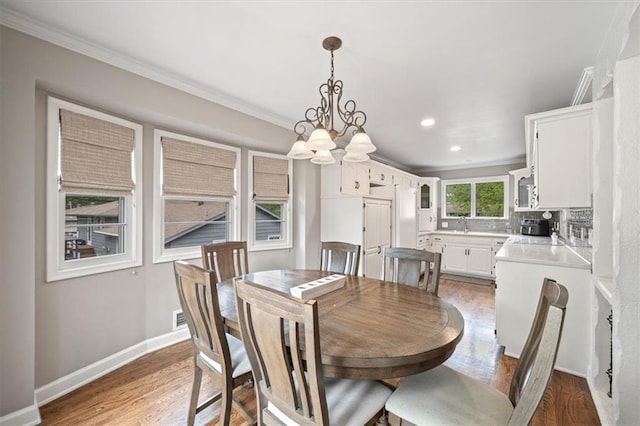 dining room featuring ornamental molding, light wood-style floors, baseboards, recessed lighting, and a chandelier