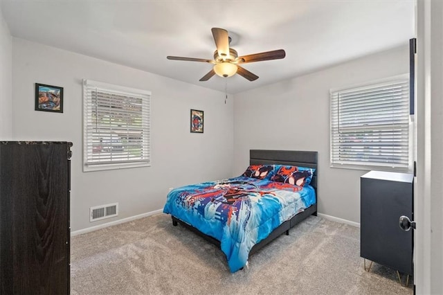 bedroom featuring carpet floors, baseboards, visible vents, and multiple windows