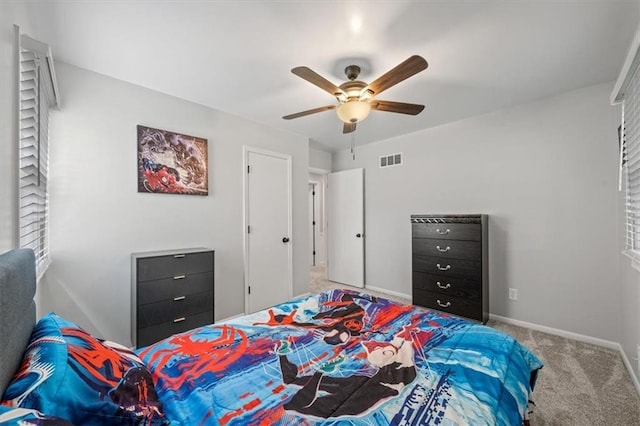 carpeted bedroom with baseboards, ceiling fan, and visible vents