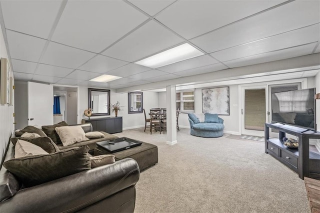 living room featuring carpet floors, baseboards, and a paneled ceiling