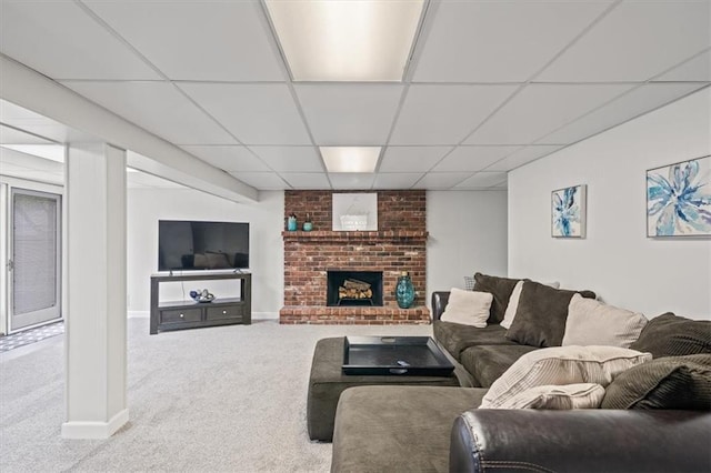 living room with a fireplace, baseboards, carpet, and a drop ceiling